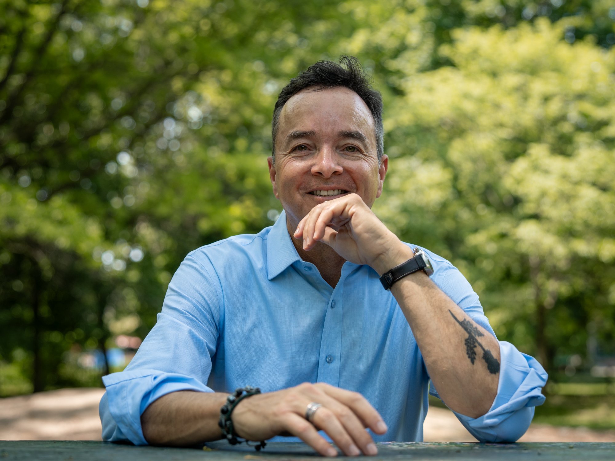 Head-and-shoulders portrait of Ian Cunningham, short dark hair, wearing a light blue button-up shirt.