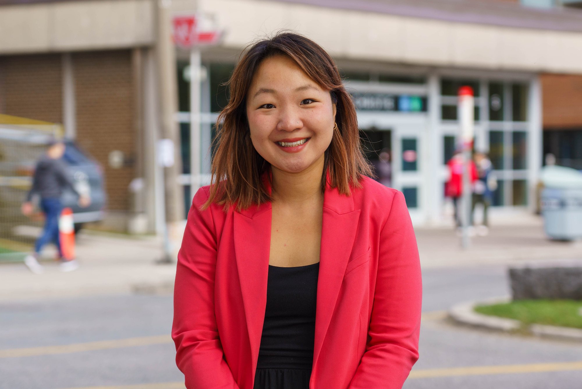 Head-and-shoulders portrait of Diana Yoon, shoulder-length dark hair with highlights, wearing a navy blazer over a pink floral top.