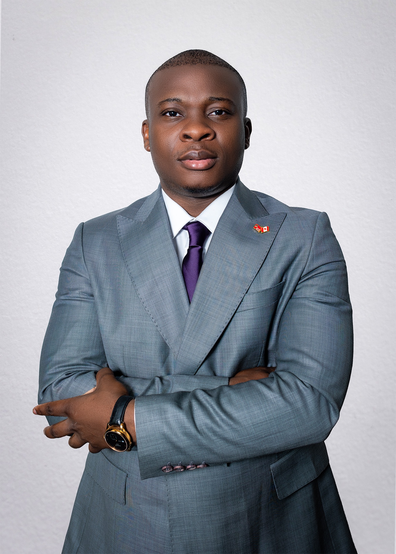 Head-and-shoulders portrait of Jethro Adir Kavod, short dark hair, wearing a grey suit, white shirt, and purple tie.