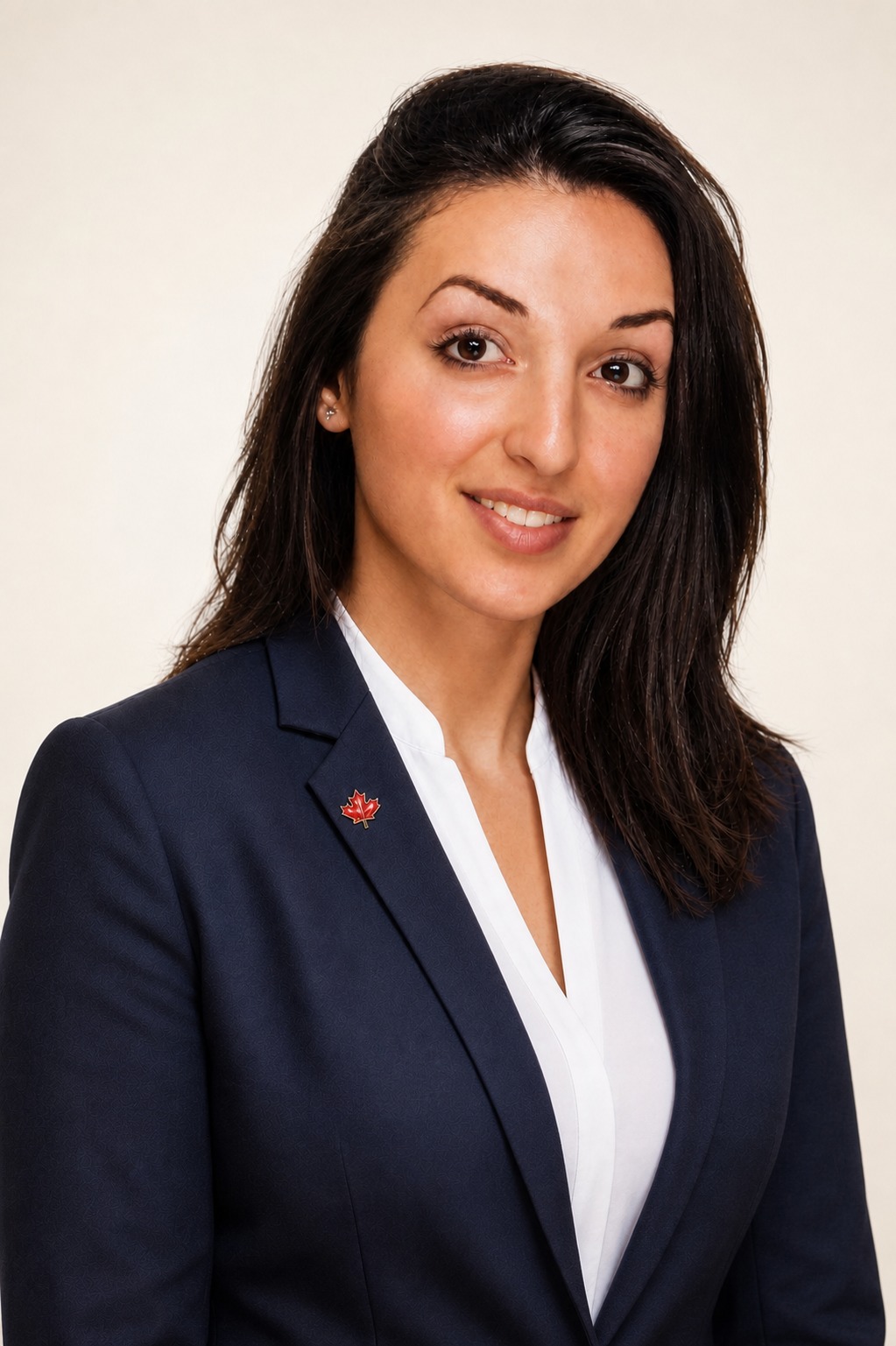Head-and-shoulders portrait of Mihaela Andrei, long dark hair, wearing a navy blazer and white blouse.