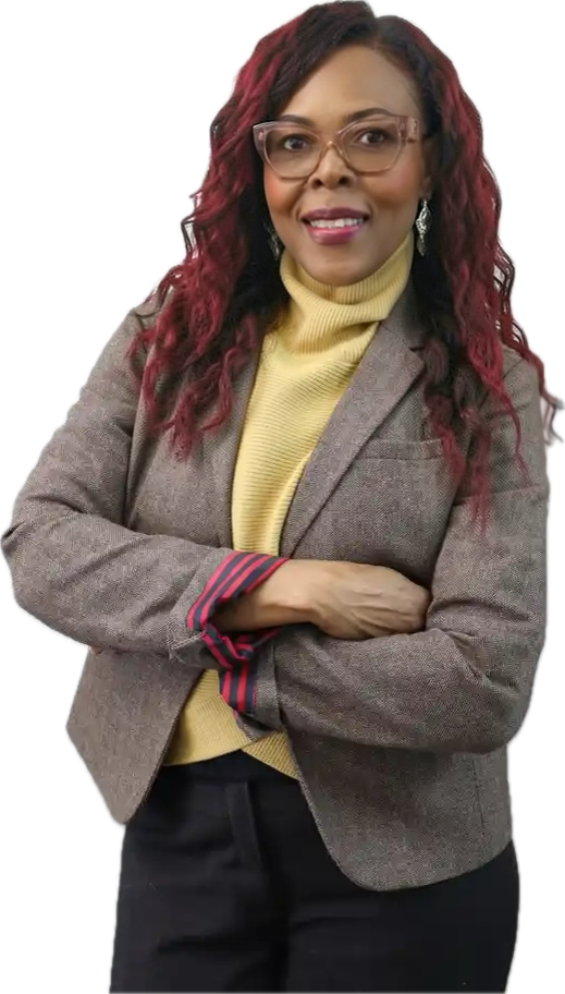 Head-and-shoulders portrait of Andrene Gregory, long dark hair with red highlights, wearing glasses and a tan blazer.