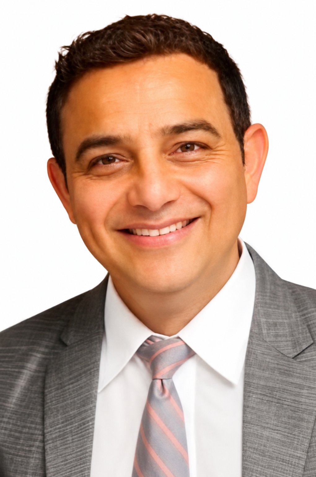 Head-and-shoulders portrait of Zakir Patel, short dark hair, wearing a grey blazer, white shirt, and striped tie.